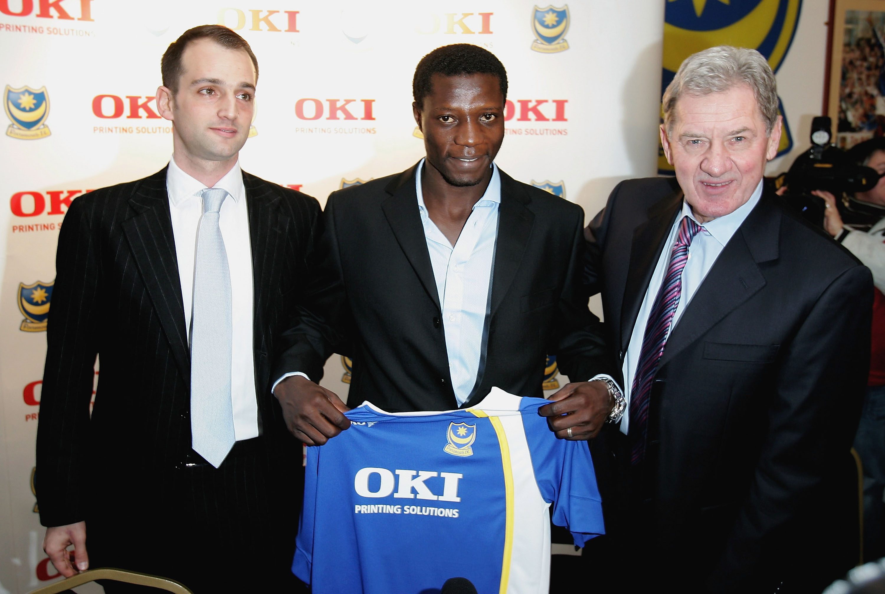 PORTSMOUTH, UNITED KINGDOM - JANUARY 06: New record signing Zimbabwe international Benjani Mwaruwari (C) is brought in as a surprise at the end of the press conference to meet Russian millionaire Alexandre Gaydamak (L) the new co-owner of Portsmouth FC during the Portsmouth FC press conference at Fratton Park on January 6, 2006 in Portsmouth, England