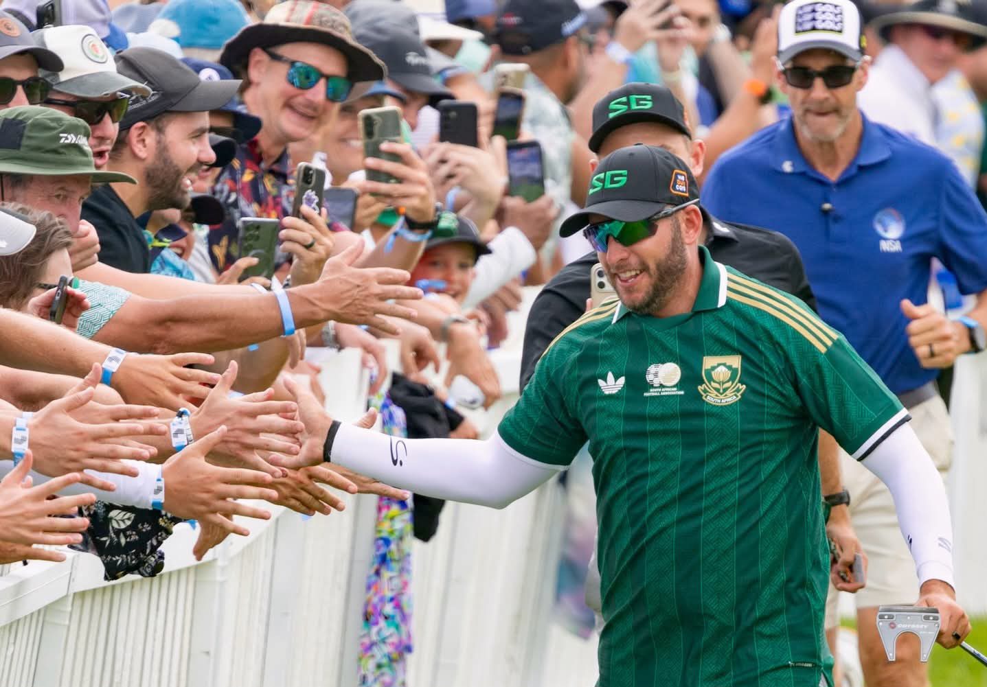 Dean Burmester greeting fans while wearing a Bafana Bafana T-shirt during the LIV Golf Tournament.