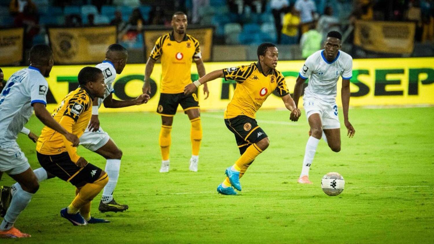 Nkosingiphile Ngcobo dribbles past Magesi FC players as his Kaizer Chiefs teammate Wandile Duba supports him