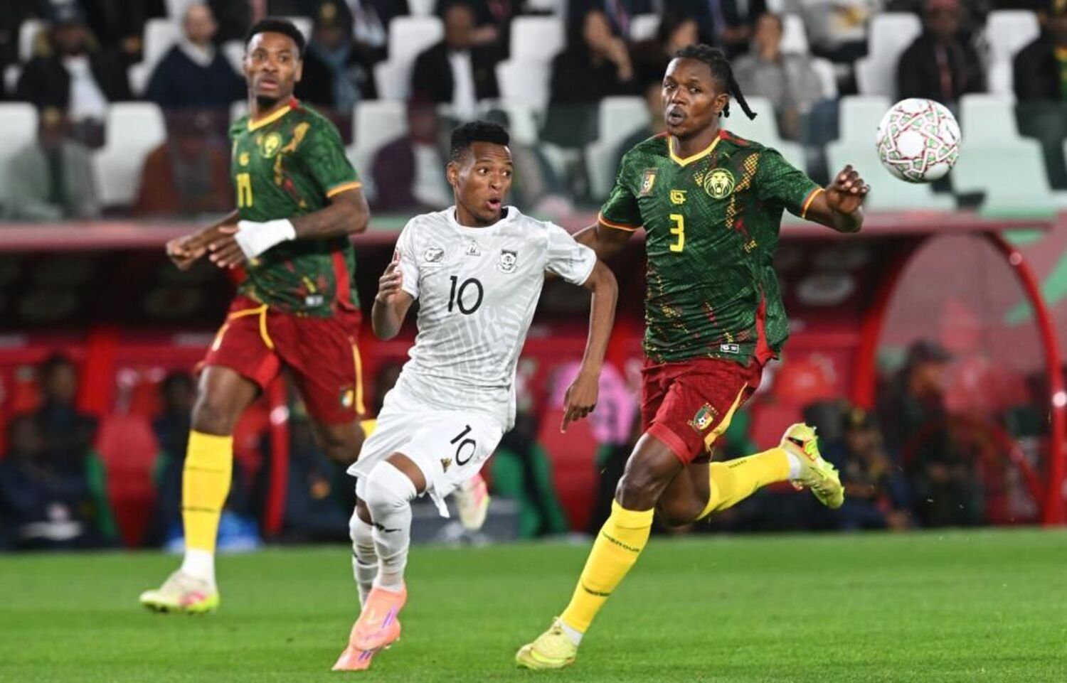 Bafana Bafana star Relebohile Mofokeng chases the ball against Cameroon players