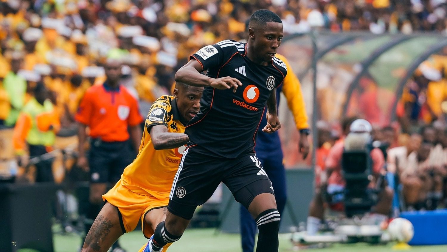 Tshepang Moremi of Orlando Pirates dribbles past Kaizer Chefs player Pule Mmodi