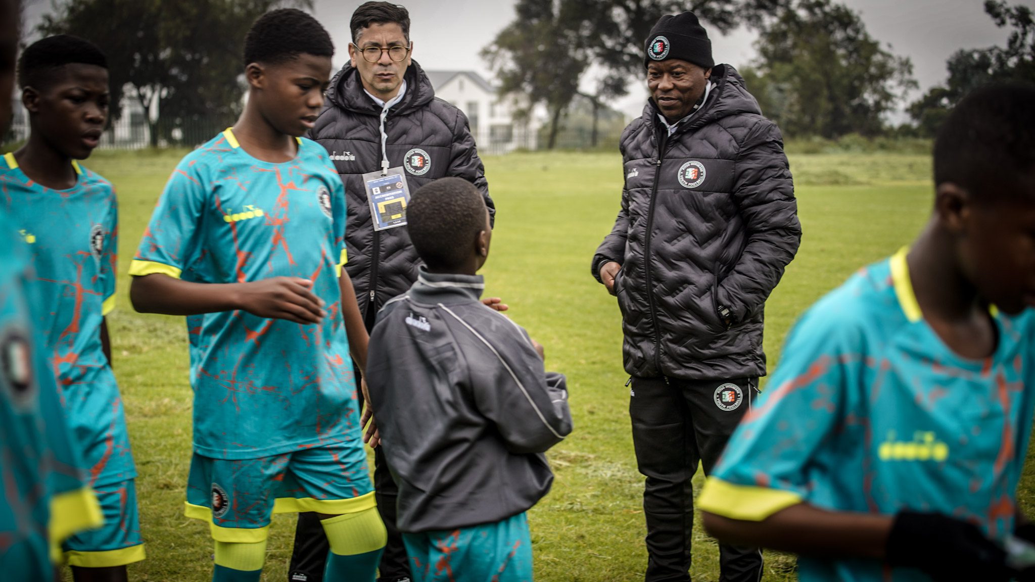 Mario Masha with Pitso Mosimane Youth Football [PMYF] players and a coach
