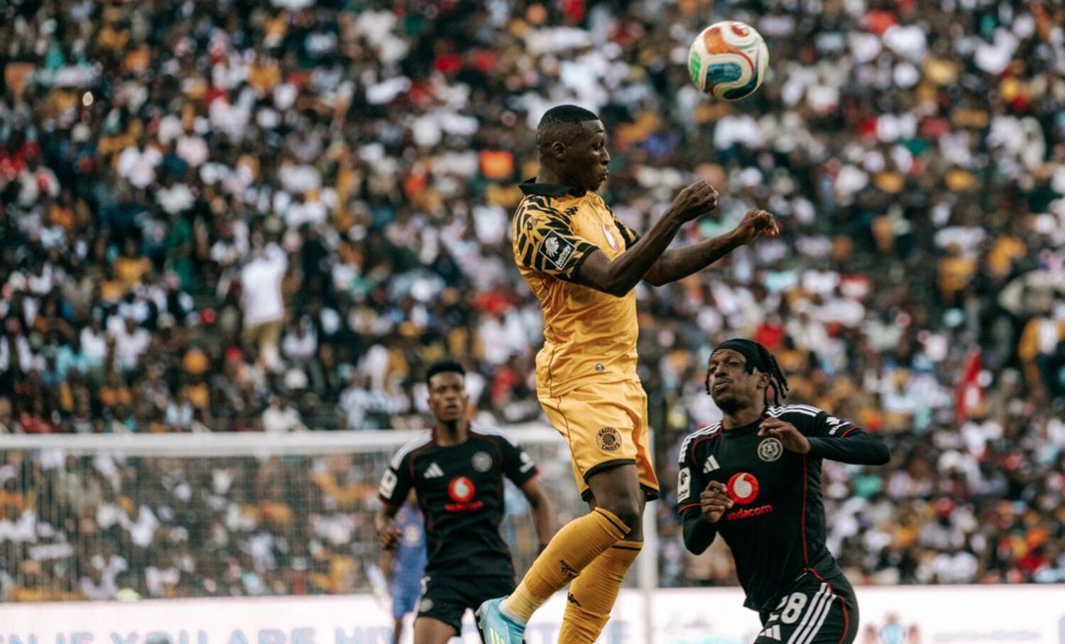 Kaizer Chiefs defender Thabiso Monyane heading the ball underf the challenge of Orlando Pirates midfielder Patrick Maswanganyi